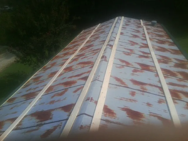 Rusted metal roof panels with new wood purlins before replacement — Storm Damage Roof Repair in Keno by Roofing Brothers
