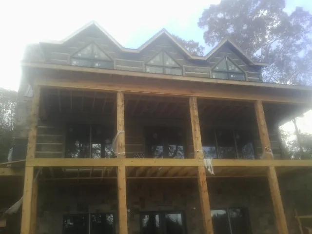 Dormers and porch framing on a large log home under construction — Roof Coating work by our crew in Keno