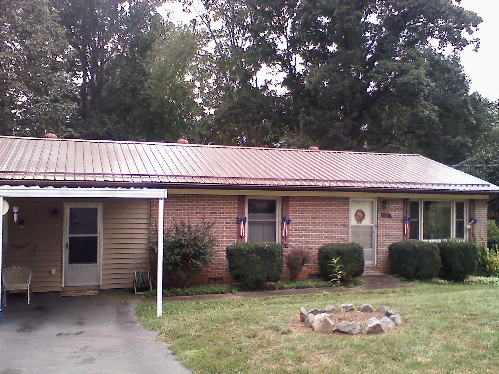 Bronze metal roof and carport on a brick ranch home — Roof Repair work by our crew in Keno