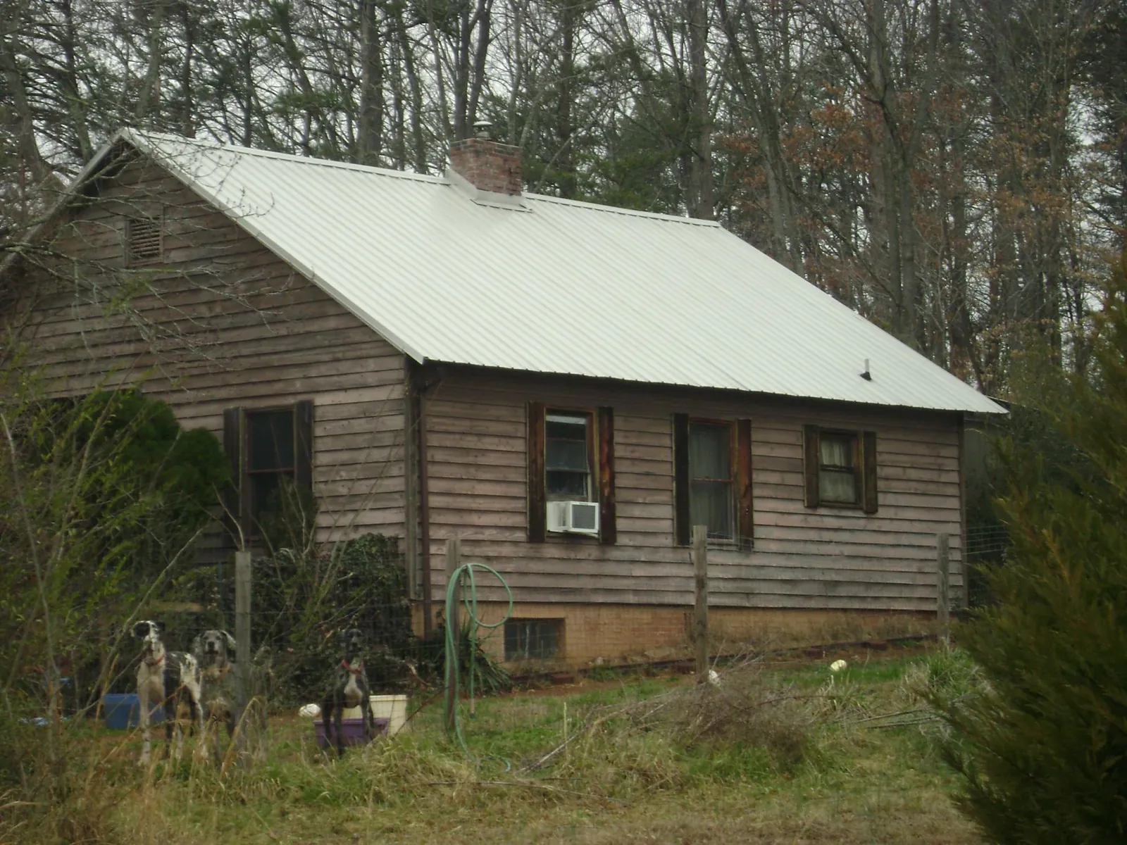 White metal roof on an old wood sided farmhouse, from a Metal Roof Installation job in Keno